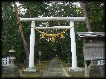 榊神社境内正面に設けられた石造鳥居と石燈籠と石造玉垣